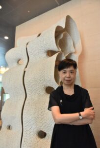 鄭雅麗執行長站立於藝術家徐永旭大型陶瓷作品《2015-36》前。