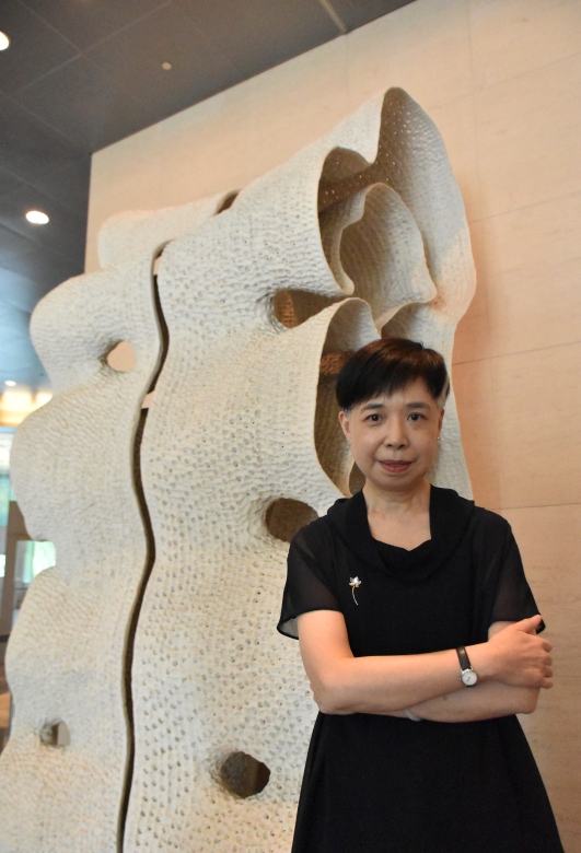 鄭雅麗執行長站立於藝術家徐永旭大型陶瓷作品《2015-36》前。